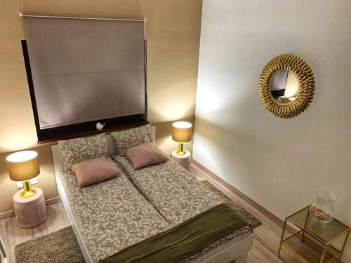 下厄尔什Panoráma apartman的一间卧室配有一张带两盏灯和镜子的床