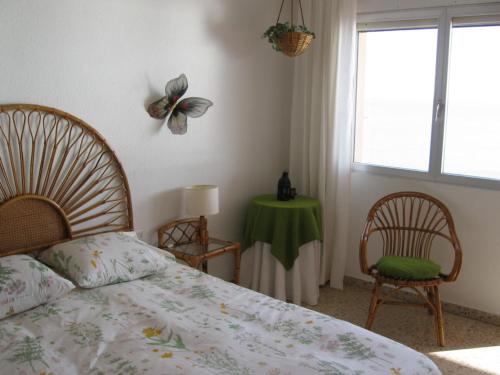 安波拉1ª LINEA DE MAR CON VISTA FANTÁSTICA的一间卧室配有一张床、一张桌子和一个窗户。