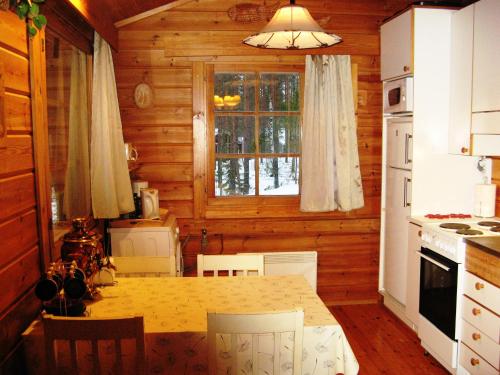 凯里迈基Коттедж на берегу живописного озера的小屋内的厨房配有桌子和窗户