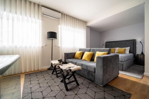 布拉加Bracara Guest House "Campo das Hortas"的客厅配有灰色的沙发和黄色的枕头。