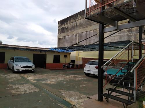 波萨达斯Departamento centrico en Posadas, garage opcional D4的两辆汽车停在大楼旁边的停车场