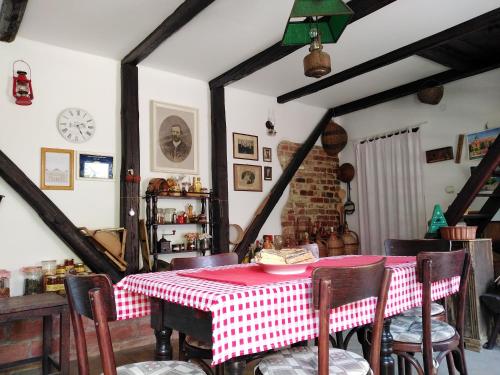 斯雷姆斯基卡尔洛夫奇Sobe Gajić Sremski Karlovci的一间用餐室,配有红色和白色的桌子和椅子