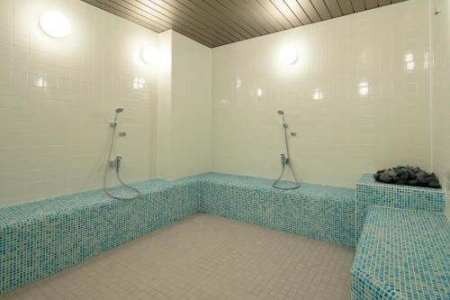 埼玉市大宫光芒酒店(Candeo Hotels Omiya)的浴室的墙壁上铺有蓝色马赛克瓷砖。