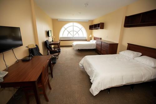 安蒂戈尼什StFX University Summer Hotel的酒店客房设有两张床、一张桌子和一台电视。
