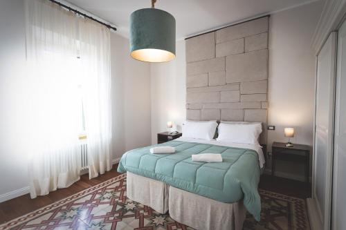 切奇纳Piazza Duomo Deluxe的一间卧室设有一张床和一个大窗户