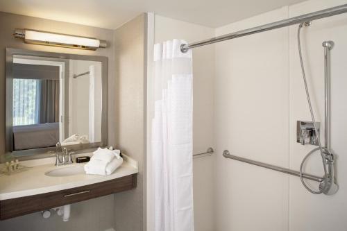 布伦特伍德富兰克林假日酒店 - 冷泉的浴室配有盥洗盆和带镜子的淋浴