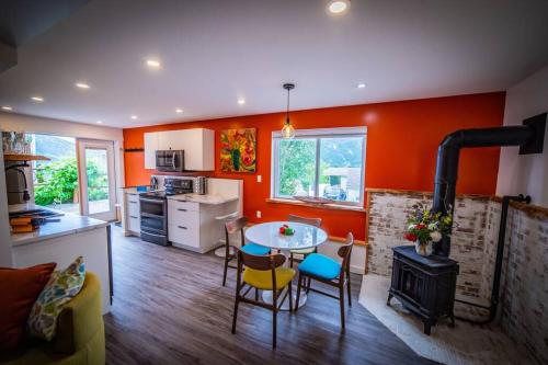 尼尔逊Gallery Suite art-cation vacation!的厨房设有橙色墙壁、桌子和炉灶。