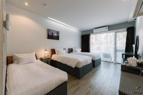 清莱Aspiraya Resort的酒店客房设有两张床和一台平面电视。