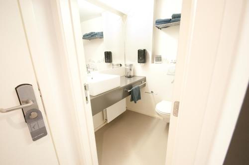 赫尔科尔比加尔酒店的白色的浴室设有水槽和卫生间。