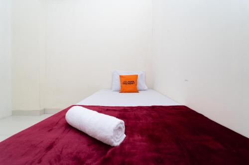 贝克西KoolKost @ Harapan Indah的一张带红色毯子和枕头的白色床