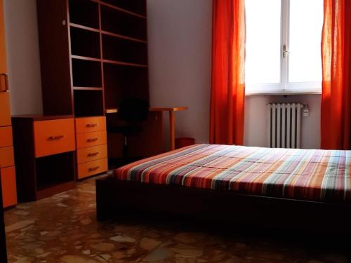 帕尔马Appartamento Soleluna的一间卧室配有一张床、一个梳妆台和一扇窗户。