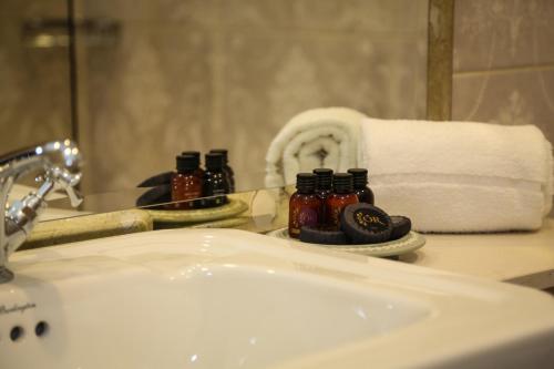 CastlecomerAvalon House Hotel的浴室水槽配有镜子和毛巾