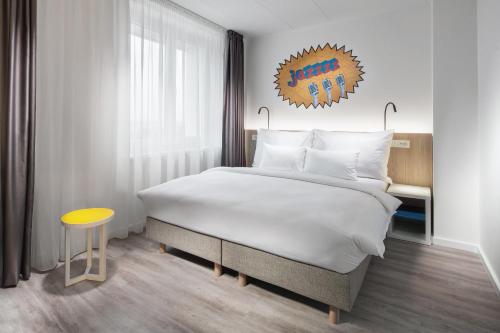 布拉格Comfort Hotel Prague City的一间卧室设有一张大床和一张黄色的桌子。