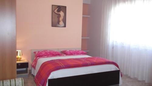 SoletoIl campanile的一间卧室配有带粉红色枕头的床和窗户。