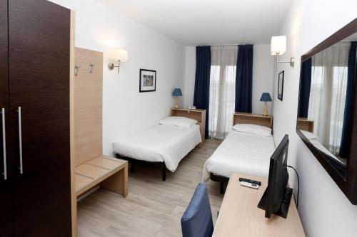 罗马欧罗巴花园酒店的酒店客房配有两张床和一张书桌