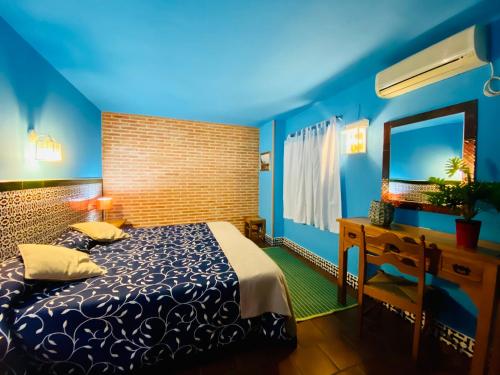 阿拉色那埃斯坦西亚罗西略别墅的一间蓝色卧室,配有一张床和镜子