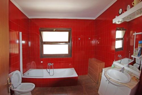 卡隆赫Club Villamar - Anabel的红色的浴室设有浴缸、卫生间和水槽。
