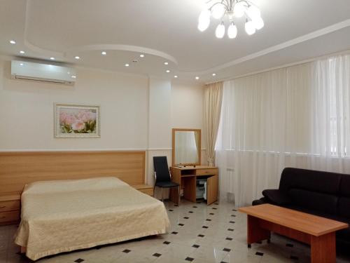 索契索科尔酒店的一间卧室配有一张床、一张沙发和一张书桌