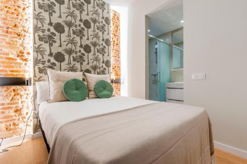 马德里Apartamentos con encanto en La Latina的一间卧室配有一张大床和两个绿色枕头