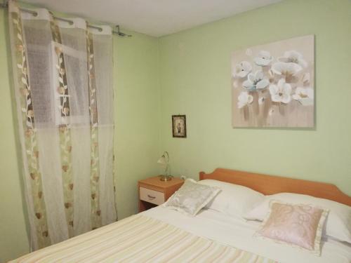 拉茨斯切I&J Relaxing Beach Apartments的一间卧室配有一张床,并展示着鲜花