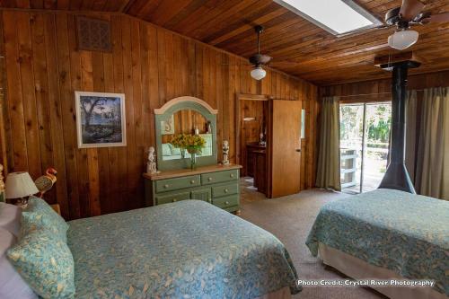 霍莫萨萨Riverfront Treetop Bungalow的一间卧室配有两张床和一个带镜子的梳妆台