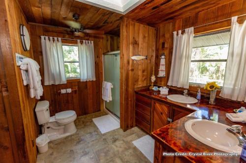 霍莫萨萨Riverfront Treetop Bungalow的木制浴室设有卫生间和水槽