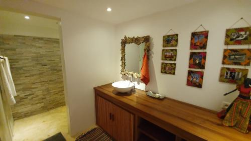 阿姆巴托洛阿卡LE TRANSAT的浴室设有水槽和镜子,位于柜台上