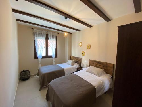 赫纳尔瓜西尔Alojamiento Rural El Refugio的一间卧室设有两张床和窗户。