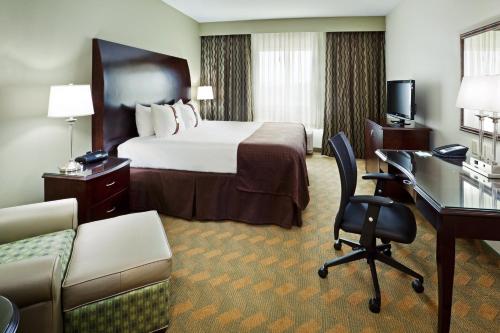 岩石丘罗克山假日酒店的配有一张床和一张书桌的酒店客房