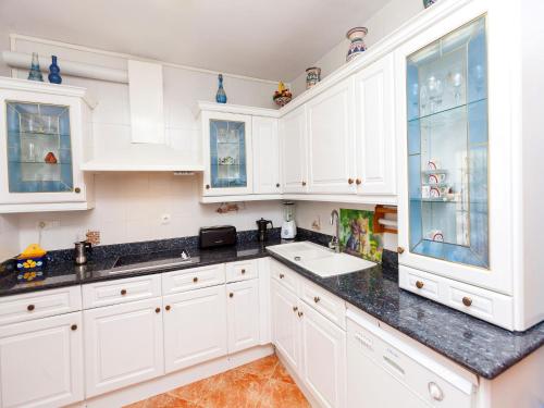 库尼特Holiday Home Katy by Interhome的厨房配有白色橱柜和水槽