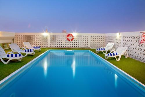 迪拜置地广场酒店 的一个带椅子的游泳池和一个游泳池