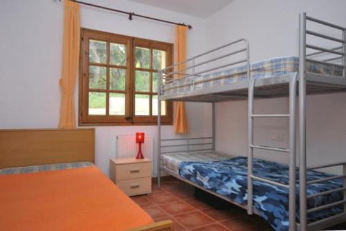 卡隆赫Club Villamar - Guayana的一间卧室设有两张双层床和一扇窗户。