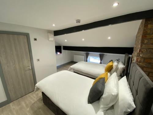 普雷斯顿6Adelphi的一间卧室设有两张床和砖墙