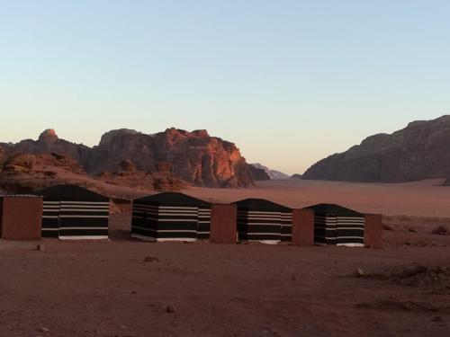 瓦迪拉姆Wadi Rum的沙漠中的一座建筑,以群山为背景