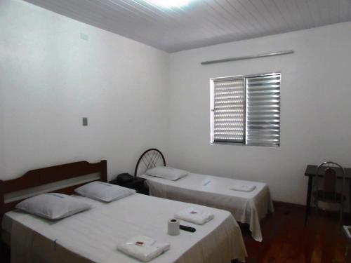 圣保罗Teodoro Palace Hotel a 5 minutos do Brás e Bom Retiro的白色客房的两张床,设有窗户