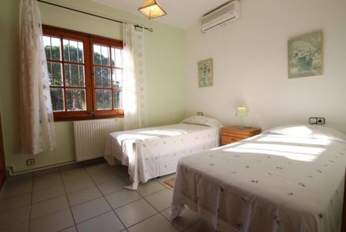 卡隆赫Club Villamar - Senona的一间卧室设有两张床和窗户。