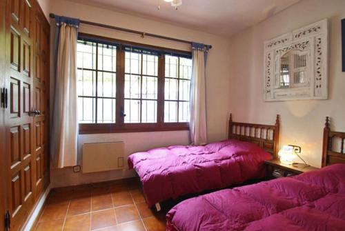 卡隆赫Club Villamar - Sophie的一间卧室设有两张床和窗户。