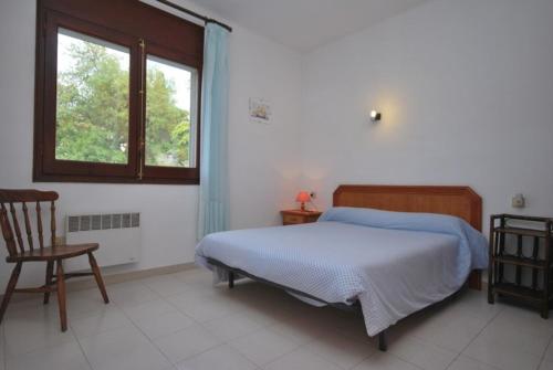 卡隆赫Club Villamar - Can Pere的一间卧室设有一张床、一个窗口和一把椅子