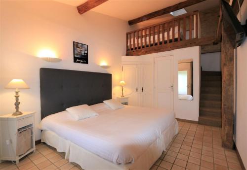 梅拉尔斯Hôtel de la Ferme Lamy的卧室设有一张白色大床和楼梯。