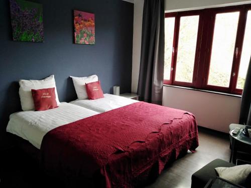 胡法利兹毕多雷斯基床和早餐的一间卧室配有一张带红色毯子的大床