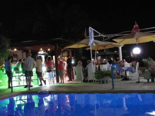 加藤-达拉特索太阳城酒店的一群人晚上站在游泳池周围