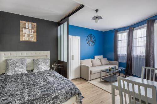 托尔西Appartements proche Paris Disney的卧室拥有蓝色的墙壁,配有一张床和一张沙发