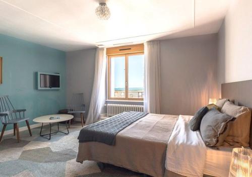 康卡勒Kêr L - Breizh & Breakfast的一间卧室配有一张床、一张桌子和一个窗户。