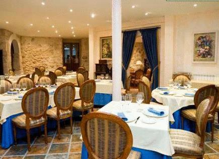 Curiel de Duero库列尔城堡皇家庄园酒店的餐厅内带桌椅的用餐室