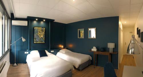 坦耶尔米塔格杏酒之家酒店的一间卧室设有两张床和蓝色的墙壁