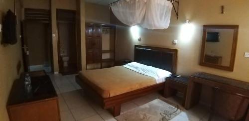 莫罗戈罗Hotel Oasis的一间小卧室,配有一张床和镜子
