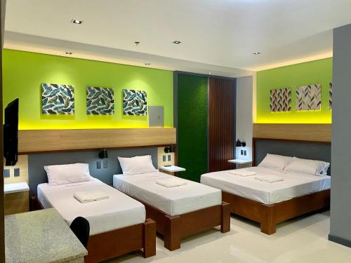 土格加劳Kara’s Pension House的绿墙客房内的两张床