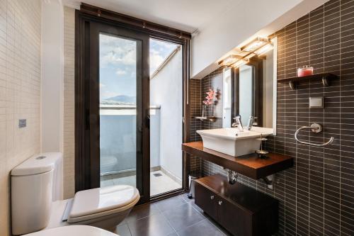 塞萨洛尼基Melon Suites的一间带水槽和卫生间的浴室以及窗户。