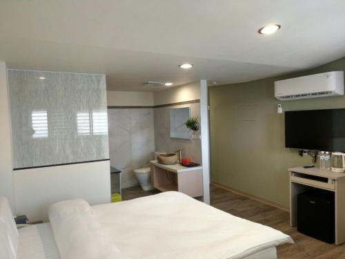 礁溪YY Elleys Home的客房设有一张床和一间带卫生间的浴室