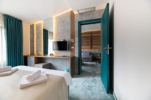 贝尔格莱德Hotel Nota的酒店客房设有两张床和电视。
